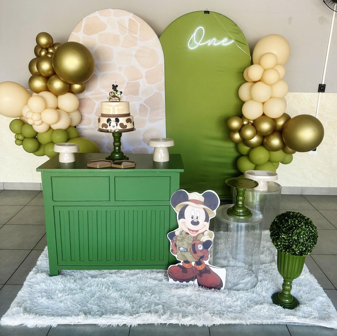 Decoração de 1 ano tema Mickey safári com dois painéis arco (girafa e verde), neon One, balcão verde e arcos de balões verdes, nude e dourados