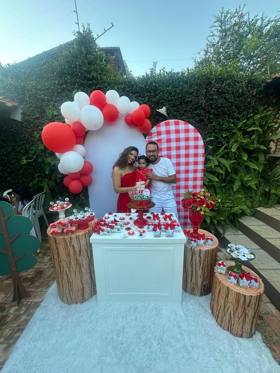 Festa infantil ao ar livre tema vermelho e branco xadrez com arco de balões, painéis arco e toras decorativas