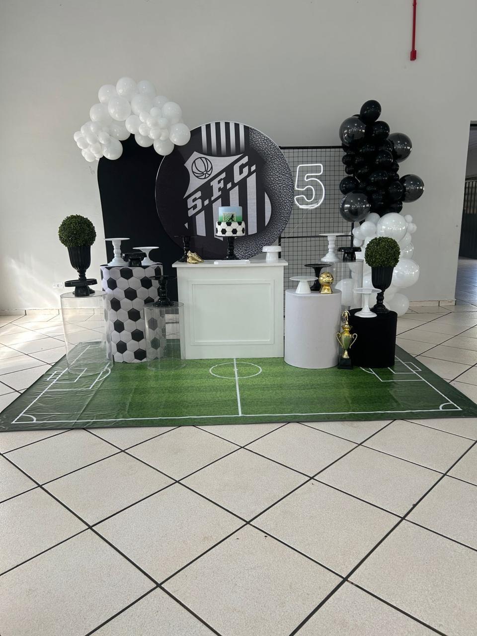 Festa infantil tema futebol Santos com painel redondo, neon número 5, cilindros preto e branco e tapete de campo