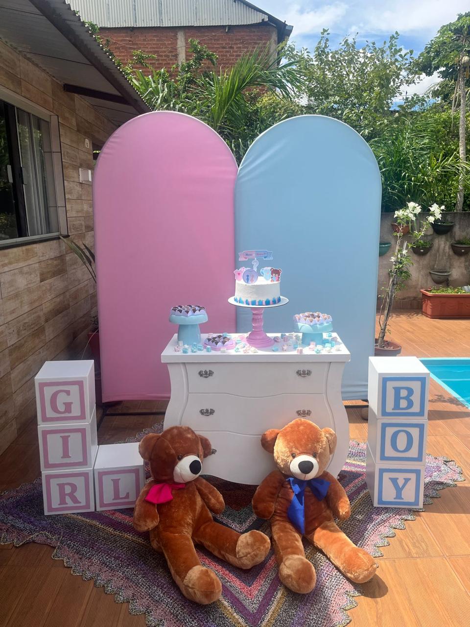 Chá revelação com painéis arco rosa e azul, cômoda branca, cubos GIRL e BOY e ursos de pelúcia